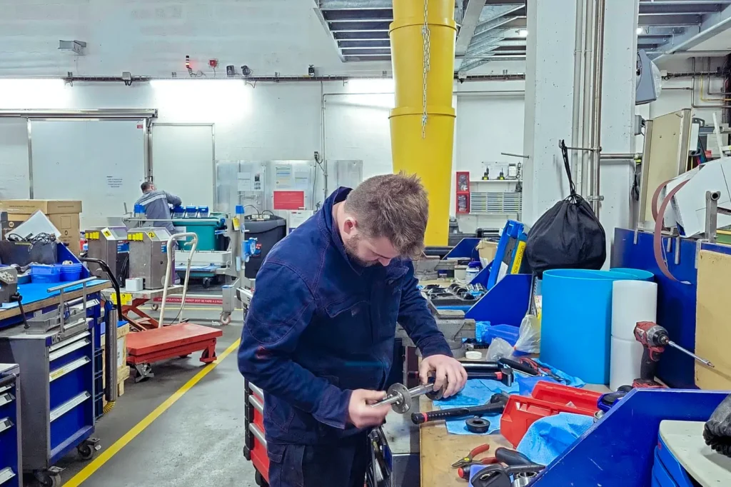 Technicien VHMI intervenant sur une machine de production en maintenance industrielle curative.